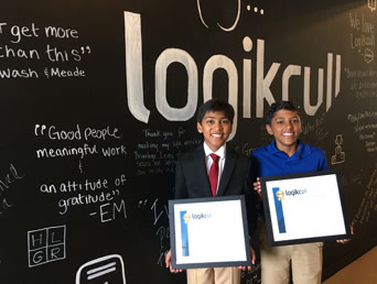 arjun and nyan holding certificates in front of logikcull blackboard